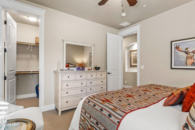 carpeted bedroom featuring a closet, ceiling fan, and a spacious closet