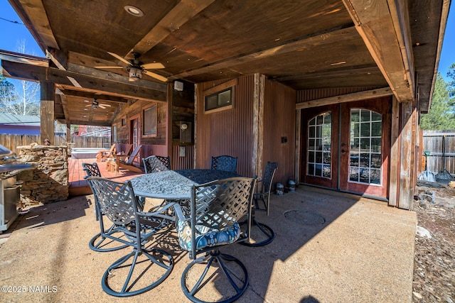 view of patio / terrace with outdoor dining space, a ceiling fan, a fenced backyard, and french doors