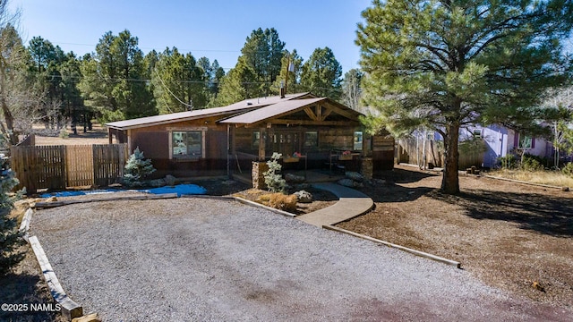 back of house featuring driveway and fence