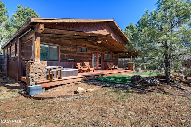 back of property featuring french doors, a hot tub, fence, and a deck