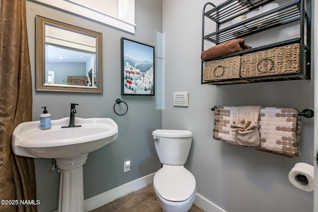 half bathroom with toilet and baseboards