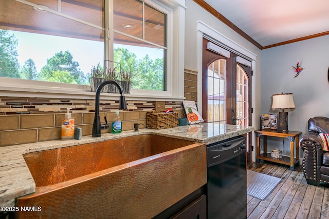 kitchen featuring wood finished floors, a sink, ornamental molding, dishwasher, and tasteful backsplash