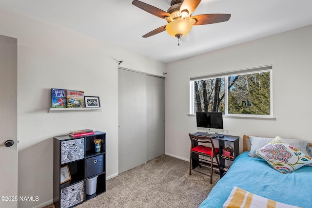 carpeted bedroom featuring ceiling fan and a closet