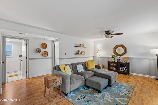 living room with ceiling fan and light hardwood / wood-style flooring