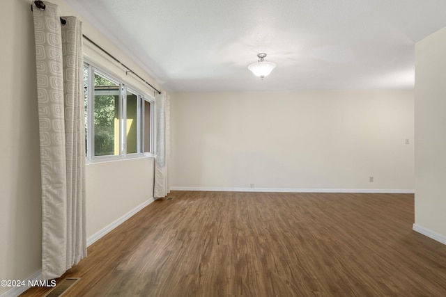 unfurnished room featuring dark wood-type flooring