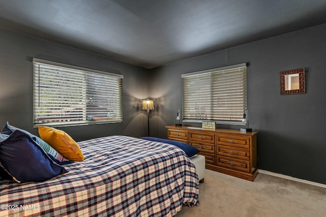 bedroom with baseboards and light carpet