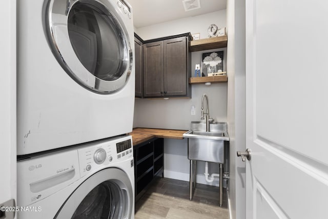 2385 W Mission Timber Cir, Flagstaff, AZ 86001 - clothes washing area featuring cabinet space, stacked washer / drying machine, light wood-style flooring, and baseboards