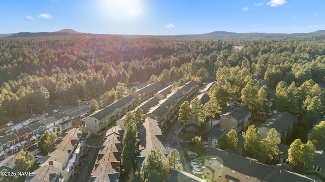 birds eye view of property with a wooded view, a mountain view, and a residential view