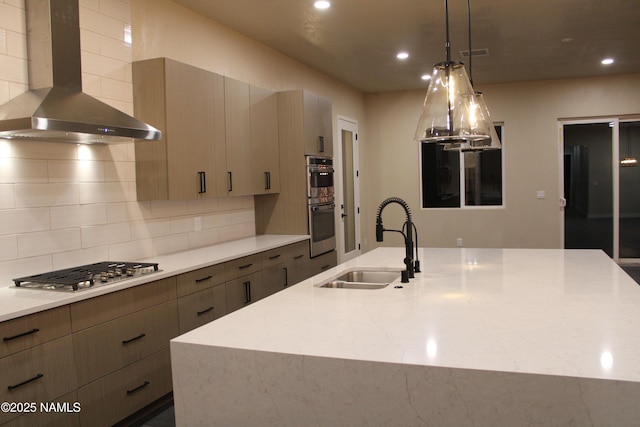 kitchen with sink, hanging light fixtures, stainless steel appliances, light stone countertops, and wall chimney exhaust hood