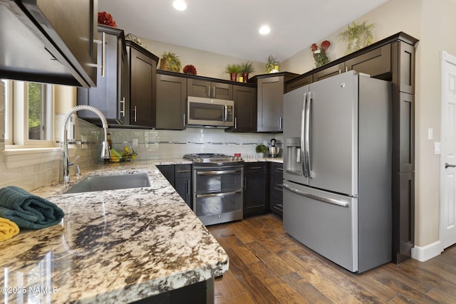 1248 W Lil Ben Trl, Flagstaff, AZ 86001 - kitchen with appliances with stainless steel finishes, a sink, dark brown cabinets, light stone counters, and backsplash