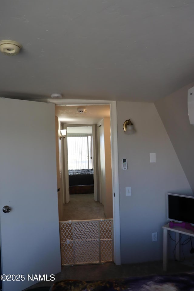 corridor featuring carpet floors and vaulted ceiling