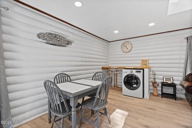 dining area with light hardwood / wood-style floors, log walls, and washer / clothes dryer