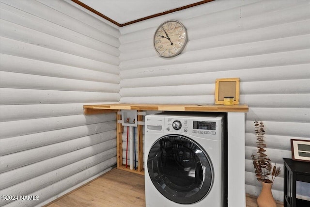 clothes washing area with rustic walls, hardwood / wood-style floors, and washer / dryer