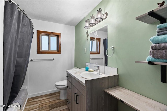 bathroom with hardwood / wood-style flooring, a textured ceiling, toilet, and vanity