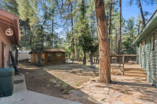 view of yard featuring a storage shed and a deck