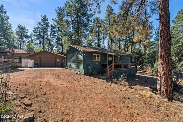 view of front of home featuring covered porch, an outdoor structure, and a garage