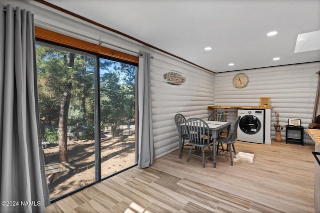 dining space with crown molding, light hardwood / wood-style flooring, log walls, and washer / dryer