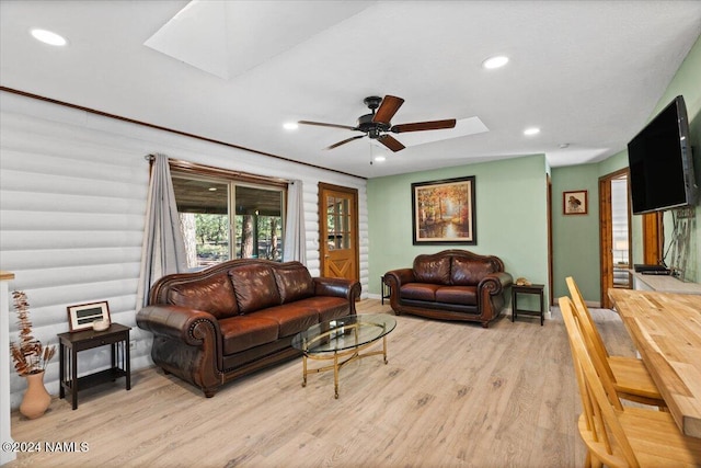 living room featuring light hardwood / wood-style floors, a skylight, and ceiling fan