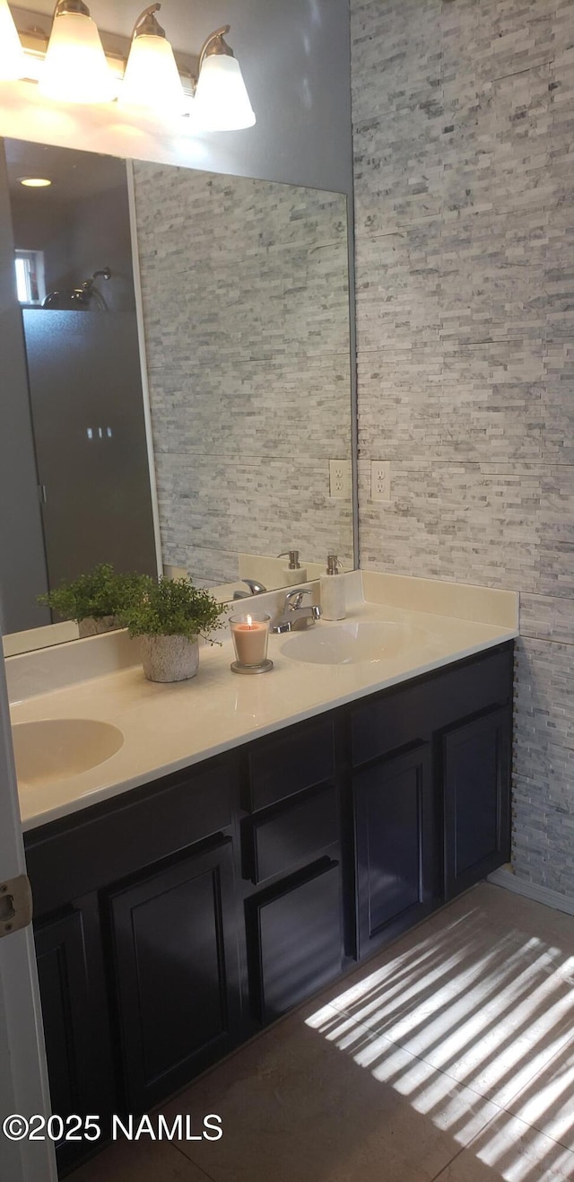 full bathroom with a sink and double vanity