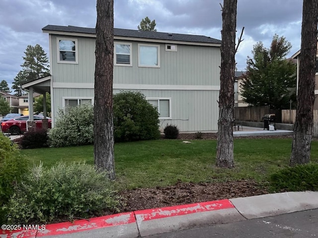 view of side of home with a lawn and fence