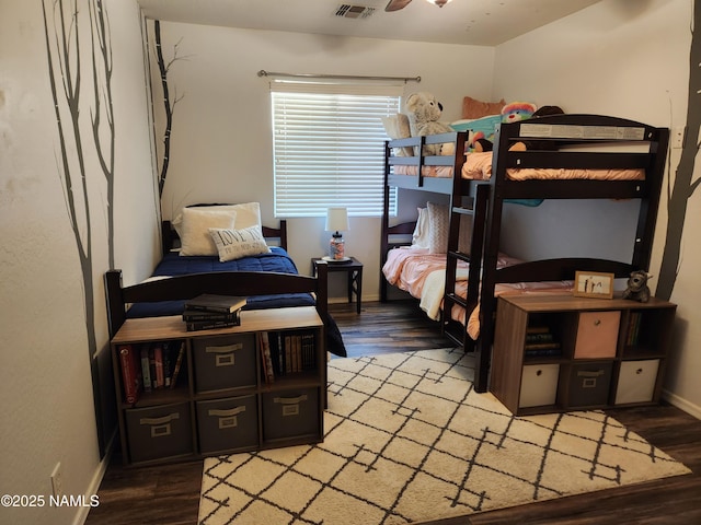 bedroom with wood finished floors, visible vents, and baseboards