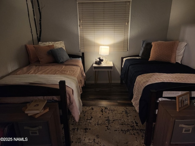 bedroom with baseboards and wood finished floors