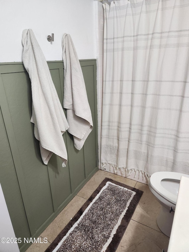 bathroom with toilet and a shower with shower curtain