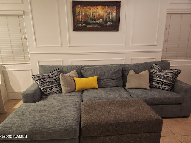 living area featuring light tile patterned flooring and a decorative wall