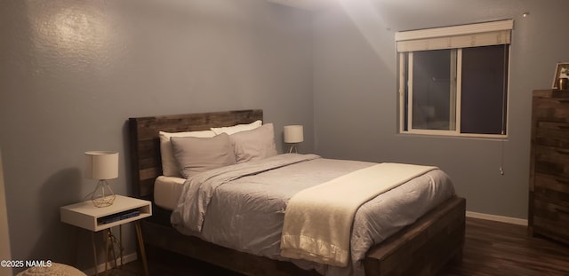 bedroom featuring baseboards and wood finished floors