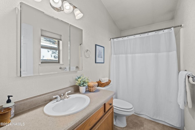 bathroom with vaulted ceiling, toilet, vanity, and tile patterned flooring