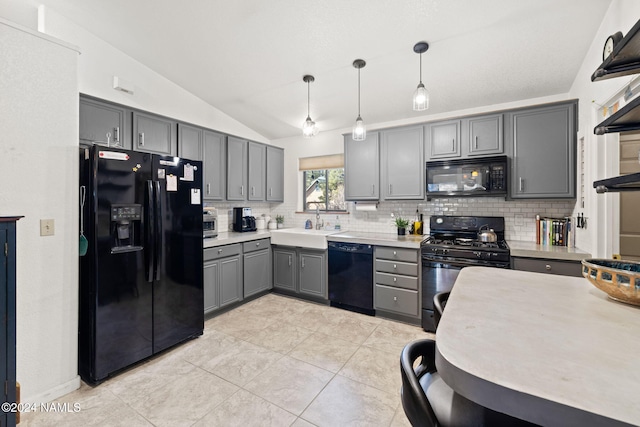 kitchen with vaulted ceiling, decorative light fixtures, gray cabinetry, black appliances, and decorative backsplash