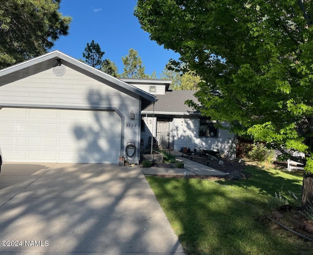 view of front of home featuring a garage and a front lawn