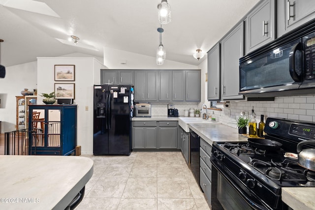 kitchen featuring hanging light fixtures, black appliances, gray cabinetry, and lofted ceiling