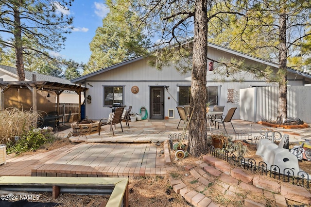 rear view of house featuring a patio, a pergola, and a fire pit