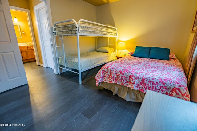 bedroom featuring dark hardwood / wood-style floors and ensuite bath