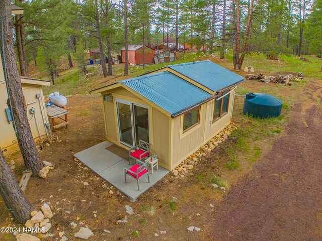 view of home's exterior featuring a patio area and a storage shed