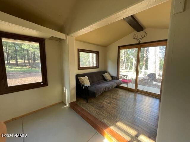 living area featuring vaulted ceiling with beams