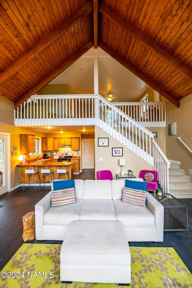 living room featuring wood ceiling, a high ceiling, and dark wood-type flooring