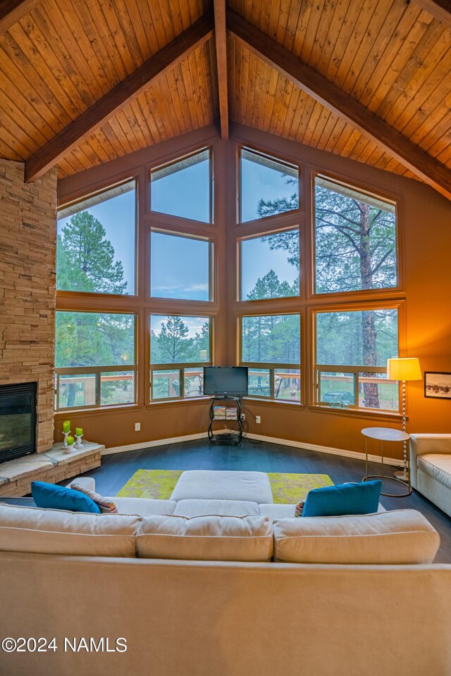 carpeted living room featuring a fireplace, wooden ceiling, beamed ceiling, and a wealth of natural light