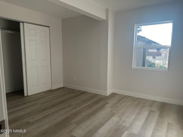 515 W Aspinwall St, Winslow, AZ 86047 - unfurnished bedroom featuring wood finished floors, a closet, and baseboards