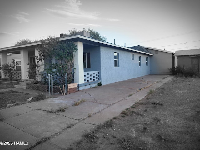 515 W Aspinwall St, Winslow, AZ 86047 - view of front of house featuring stucco siding, concrete driveway, and a gate