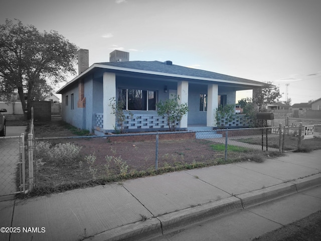 515 W Aspinwall St, Winslow, AZ 86047 - view of front of home featuring a porch, a chimney, a fenced front yard, and stucco siding