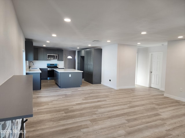 515 W Aspinwall St, Winslow, AZ 86047 - kitchen with appliances with stainless steel finishes, recessed lighting, light countertops, a kitchen island, and light wood-style floors