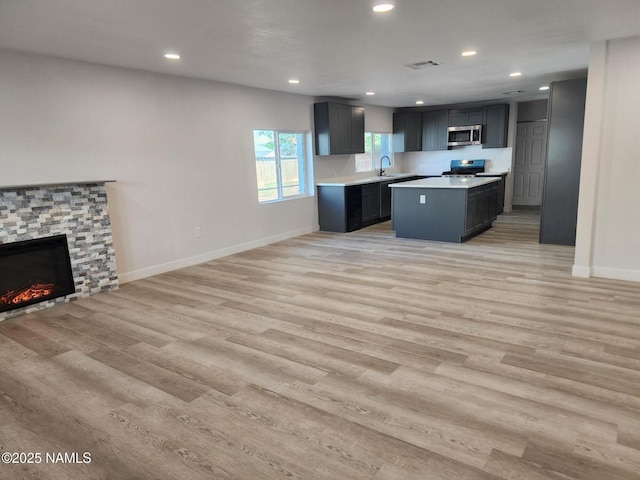 515 W Aspinwall St, Winslow, AZ 86047 - kitchen with appliances with stainless steel finishes, light countertops, open floor plan, a fireplace, and recessed lighting
