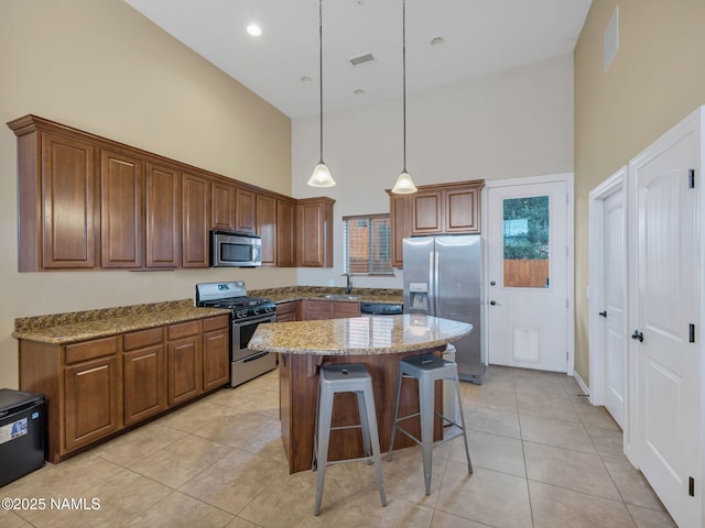 449 E Woodland Dr, Flagstaff, AZ 86001 - kitchen featuring visible vents, a kitchen bar, light stone counters, appliances with stainless steel finishes, and a sink