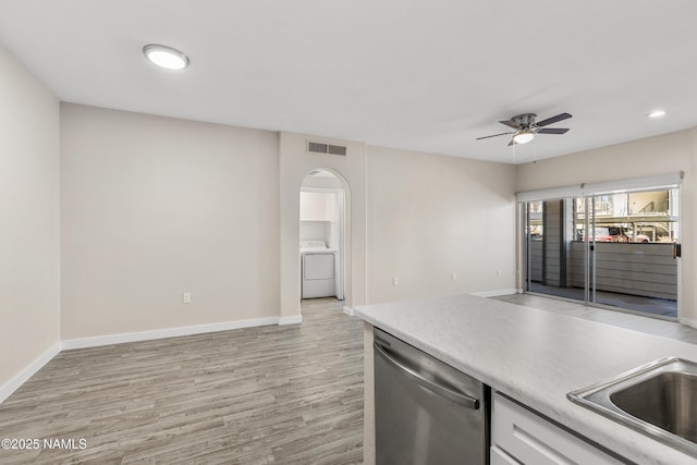 kitchen with washer / clothes dryer, light hardwood / wood-style floors, sink, ceiling fan, and stainless steel dishwasher