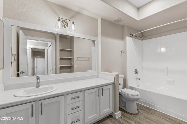 full bathroom with hardwood / wood-style floors, shower / tub combination, toilet, and vanity