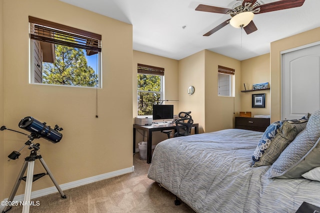 carpeted bedroom with a ceiling fan and baseboards