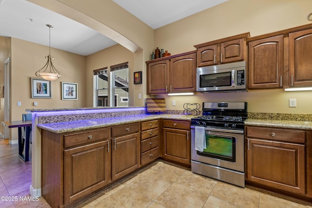 kitchen with stainless steel appliances, a peninsula, light tile patterned floors, and hanging light fixtures