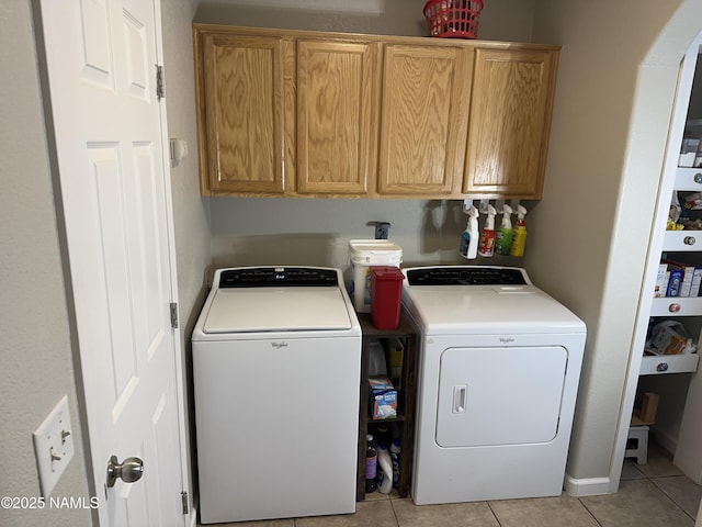 laundry room featuring light tile patterned floors, cabinet space, and washer and clothes dryer